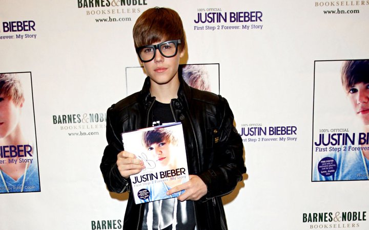 Here: Justin Bieber holds up a copy of his new book as he arrives at Barnes 